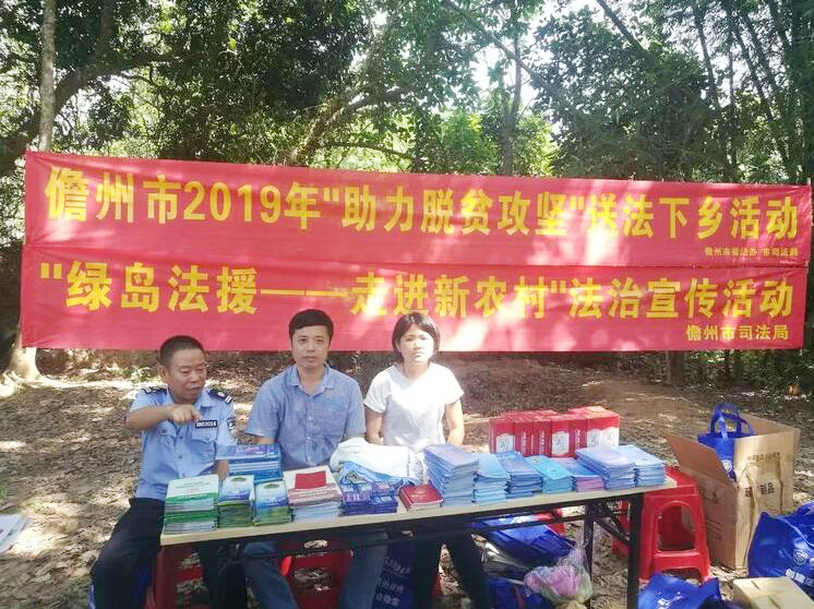 海南省儋州市司法局开展法治扶贫宣传服务活动，为群众发放《百姓法治宝典》